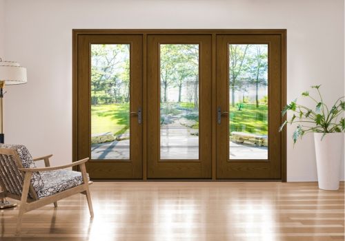 Hinged patio door with three glass panels in a modern living room, opening to a lush backyard view.