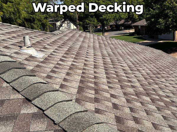 "Asphalt shingle roof with visible waves and uneven surfaces caused by warped decking — a structural issue that can lead to leaks, reduced lifespan, and costly roof repairs.