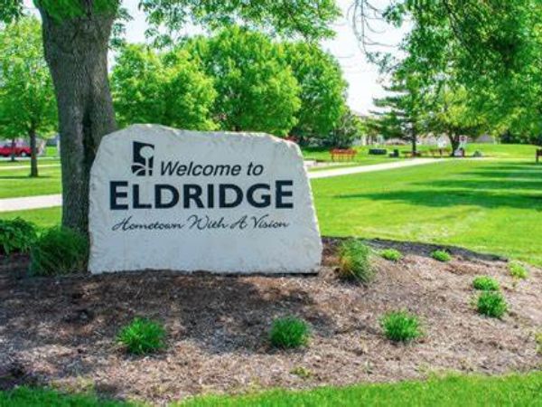 Welcome to Eldridge sign in a park, showcasing a hometown with a vision, for an Eldridge, IA roofing, windows, and siding company.