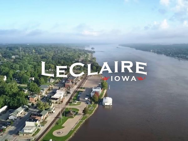 Aerial view of LeClaire, Iowa along the Mississippi River, featuring the LeClaire Iowa sign, for a LeClaire, IA roofing, windows, and siding company.