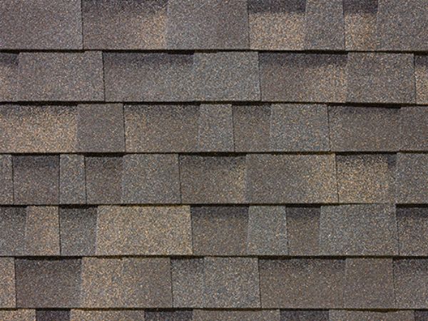 Close-up of Malarkey Weathered Wood asphalt shingles in dark gray-brown with aged texture for timeless roofing
