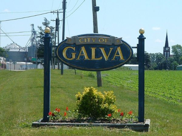 City of Galva welcome sign with flower bed and rural backdrop for roofing services