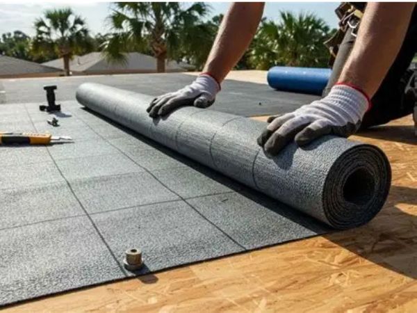 Roof underlayment being rolled out onto OSB decking